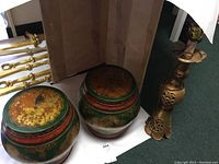 View of two painted Asian style rice barrels with lids and a brass lamp base.