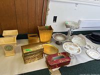Lot of assorted cake plates, decorative bowls, boxes, wastebasket and vases arranged on table