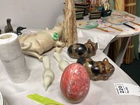 Various marble and stone figurines including animals and decorative obelisks arranged on a table.