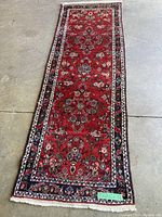 Full view of runner 2'7" x 8' labeled G, red field with floral medallion pattern and fringed ends.
