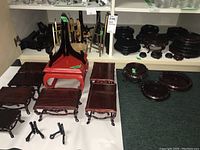 Cabinet lower shelf and floor view showing rectangular wood stands, red lacquer stand, metal plate stands and folding easels