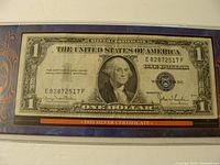 Full frontal photo of the 1935 Silver Certificate one dollar bill featuring George Washington, framed in a holder.