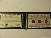 Overview of the certificate booklet and coins inside, showing the packaging and presentation style.