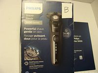 Philips Shaver 5000 Series box showing branding and product details including SteelPrecision blades and SkinIQ technology.