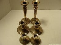 Overview of the three pairs of sterling silver candle holders showing various heights and shapes.