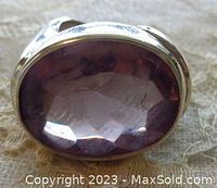 Close-up of the large faceted underneath and smooth cabochon amethyst stone bezel set in sterling silver band.