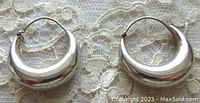 Pair of vintage sterling silver hoop earrings on lace background, showing size and shape