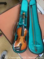 Full view of 18-inch violin inside turquoise-lined black hard case with bow included.