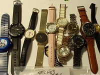 Photo showing 11 wristwatches in various styles and bands laid out side by side