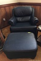 Full view of black faux leather chair with matching ottoman, showing condition and material