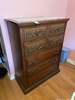 Full view of the Malcolm wood and wood laminate dresser with carved upper drawers and metal handles in a pink room