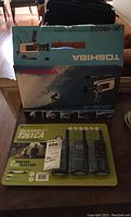 Photo of two pack and one pack of Motorola Talkabout T261CA two-way radios in original packaging, and the Toshiba IK-1900C video camera box located behind.