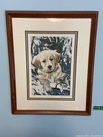 Photo of framed print of a puppy by Kathy Hagerman in wood frame, showing full piece from a distance.