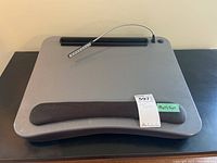 Front view of gray lap desk showing cushioned wrist rest and flexible LED light arm with multiple small LED bulbs.