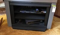 Front view showing black Sony media stand with two component shelves and some electronic components inside (not included).