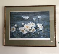 Frontal photo of the framed floral print showing white flowers and green matting.