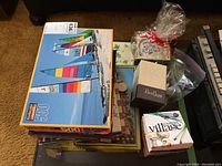 Overview of various puzzles stacked, gift wrapped item, and small decorative boxes