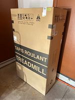 Full view of upright, sealed cardboard box labeled TREADMILL and TAPIS ROULANT, showing size and packaging condition.