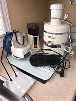 Photo showing Jack LaLanne Power Juicer, Iona coffee grinder, Cuisinart Mini-Prep processor, and Black and Decker hand mixer on countertop.