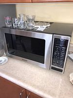 Front view of Panasonic Dimension 4 microwave on kitchen counter with glassware on top.