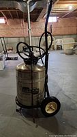 Front view of Chapin compressed air cart sprayer with pump and wheels in a basement space
