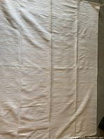 Full view of white rug showing overall size and texture with slight creases.