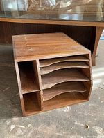 Front view showing curved horizontal slots for sorting documents and vertical storage compartments on the side.