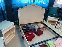 Two white wooden nightstands positioned next to a bed frame, showing overall matching design and size