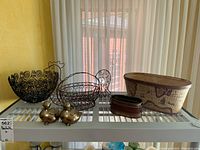 Overview of all items in the lot shown on a white shelf with curtain background