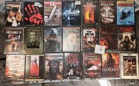 Front view of all 21 DVD cases in the horror movie lot showing artwork and titles.