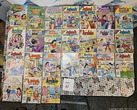 Top view of 24 Archie Comics featuring Jughead, Betty, Veronica, Archie, and related titles arranged in rows, most are Double Digest editions.