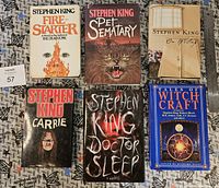 Front covers of six Stephen King hardcover books including Firestarter, Pet Sematary, Carrie, Doctor Sleep, On Writing, and Tales of Witchcraft.