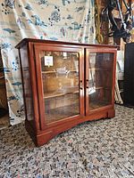 Front view of the vintage wooden glass door dresser display cabinet, showing glass doors and wood finish.