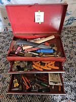 Open red 2-drawer toolbox showing a variety of hand tools inside in two drawers and the top compartment.