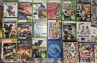 Top view of front covers showing 22 game cases for Xbox 360, PlayStation 2, Wii, and PC games.