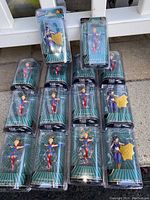 Photo showing fourteen DC Bombshells figure keychains of Supergirl and Batgirl in original packaging.