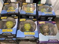 Photo of 18 vinyl collectible figures packaged in boxes: 17 Batman Dorbz Croc figures and 1 Guardians of the Galaxy Groot figure. Boxes are clearly labeled with brand and series.