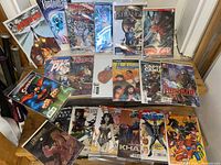 Full display of 20 variant cover comic books laid out in two rows on a floor, showing a variety of titles including Doctor Strange, Vampirella, Agents of P.I., Red Sonja, Harbinger, Captain Canuck, Superman, and others.