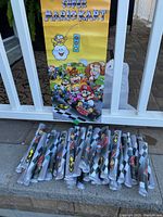 Photo showing 36 rolled posters laid out on steps with one unrolled poster leaning against a white railing.