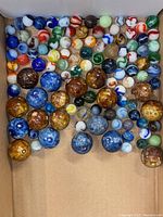 Top-down view of all assorted vintage glass marbles in assortment of sizes and colors.