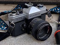 Close-up showing the front and side of the Fujica ST701 camera with lens and attached patterned strap.
