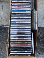 Box containing 58 CDs stacked vertically showing various artists and album titles, mixed genres.