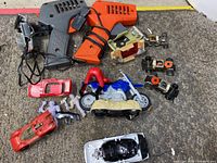 Photo showing controllers, various car bodies and chassis, motor units and wheels spread on carpet floor