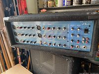 Front view of the Wharfedale PM600 Pro powered mixer showing all input channels and control knobs.