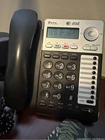 Front view of AT&T office phone showing the digital display, keypad, and handset along with line status indicators.