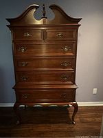 Front view of tallboy dresser showing six-drawer configuration and swan-neck pediment