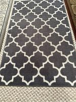 Photo showing the entire indoor mat with grey background and white Moroccan trellis pattern, dimensions 30x48 inches, very good condition.