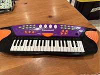 Front view of the Kawasaki electronic keyboard showing keys, control buttons, and overall shape.