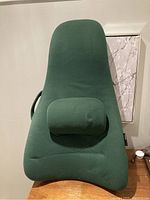 Front view of the Obus Form orthopedic back support cushion in green fabric on wooden floor.