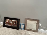 Photo showing the framed landscape picture, Desiderata plaque, and square mirror leaning against a gray wall on carpet.